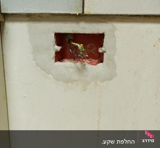 חוטי חשמל יוצאים מקיר עם חור מרובע